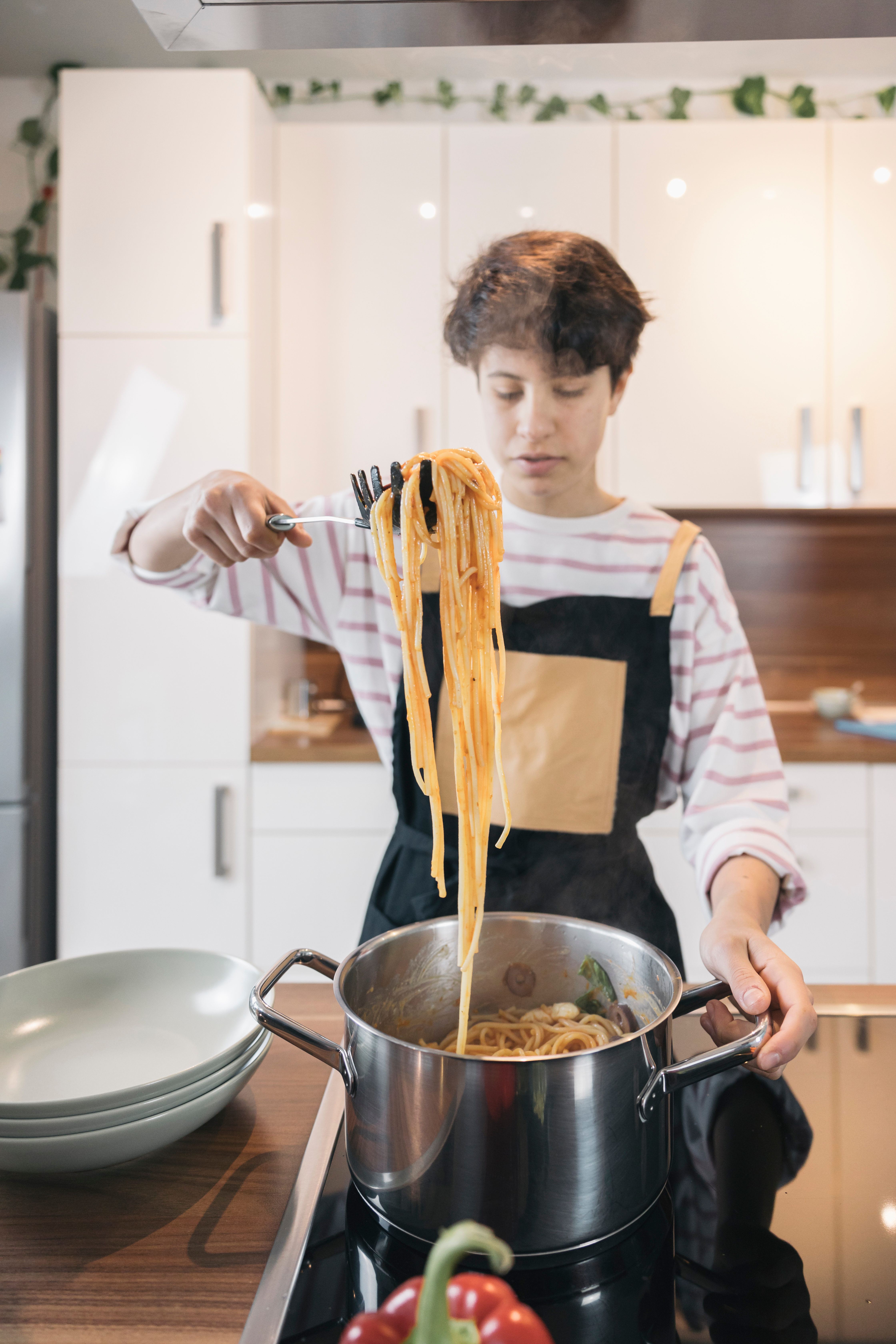 boy holding up a spoonful of spaghetti 